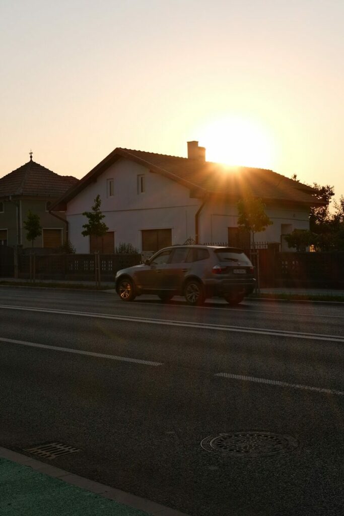 A car driving down a street at sunset